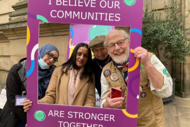 Birmingham More in Common group smiling in a purple selfie frame.