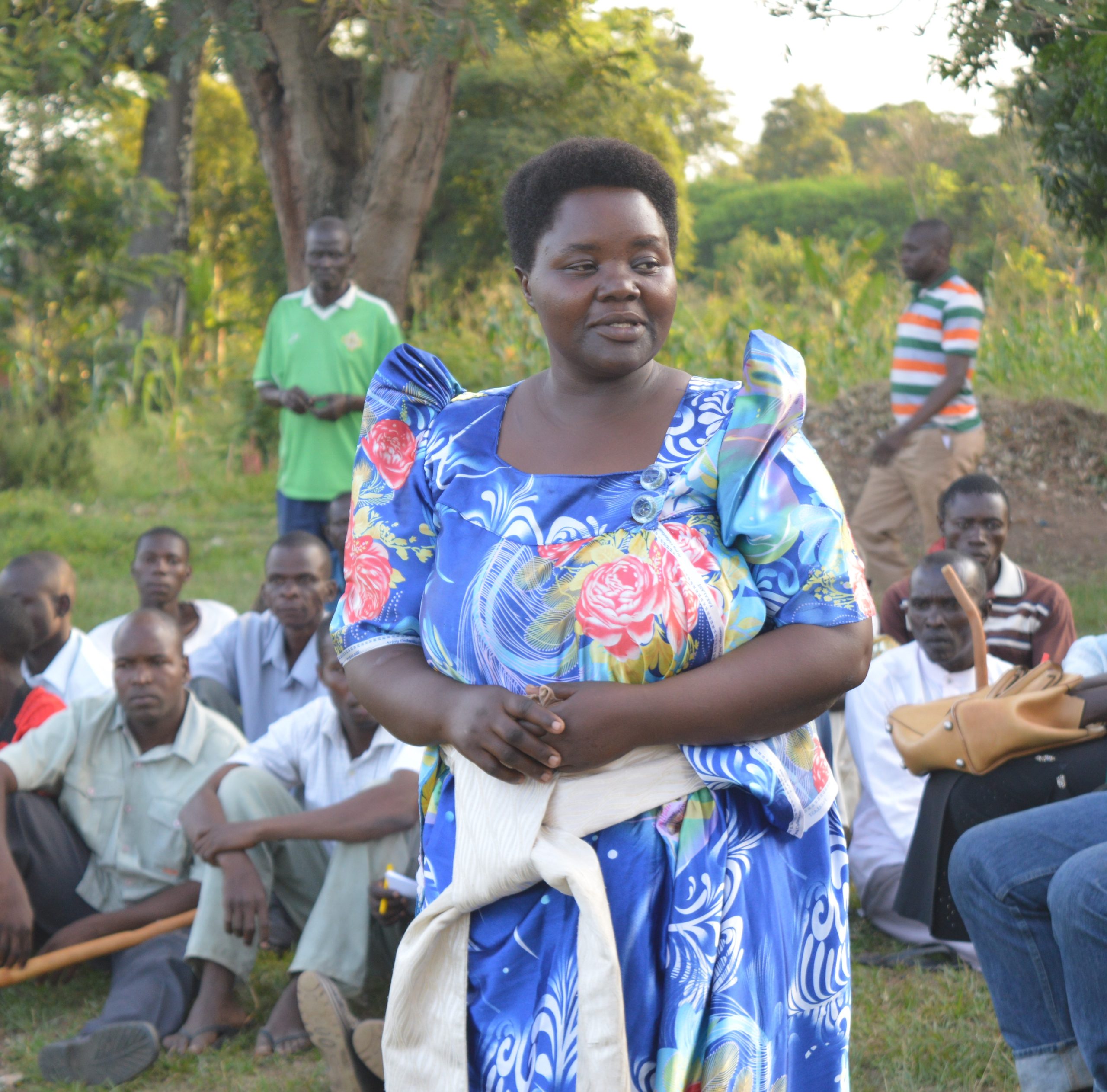 Woman in front of group of men in community