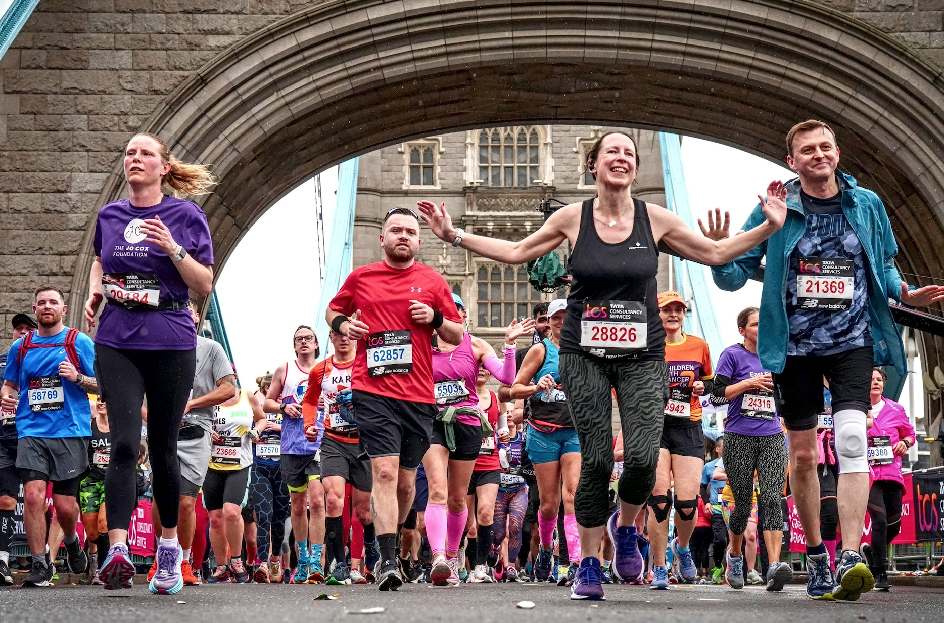Clare running under Tower Bridge with a purple Jo Cox Foundation tshirt.