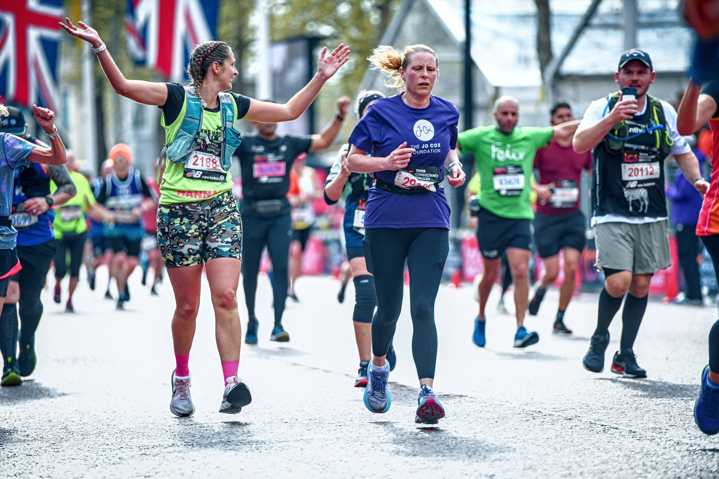 Clare running along a London street with a purple Jo Cox Foundation tshirt.